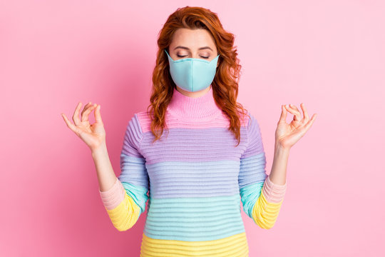 Photo of pretty relaxed lady keep social distance practicing yoga eyes closed fingers together control body and mind wear protect face mask sweater isolated pink color background