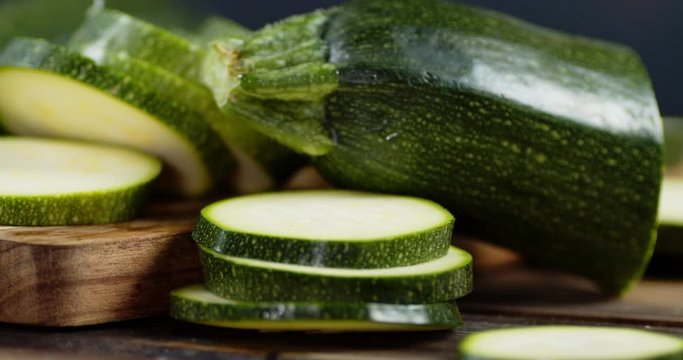 Chopped pieces of ripe zucchini on wooden cutting Board.