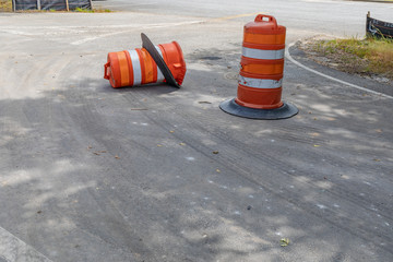 Two traffic barrels, one overturned, metaphor for safe driving, construction zone, accidents,...