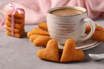 Heart shaped homemade cookies and a cup of coffee on a gray concrete background, Horizontal format, Closeup