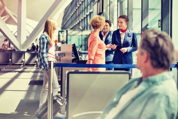 Obraz premium Mature woman on board giving her passport and boarding pass in airport 