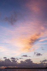 Fantastic view of a colorful sky at sunset over the sea. 
Low fluffy clouds. 
