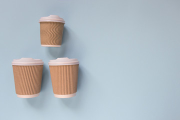 Paper cups of coffee to go on pastel background.