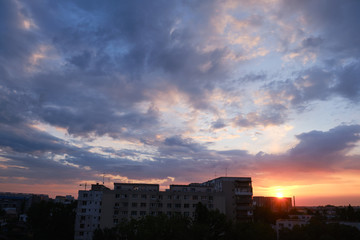 Fototapeta na wymiar Urban sunrise with purple and orange clouds in the sky, after a storm, in Bucharest, Romania.