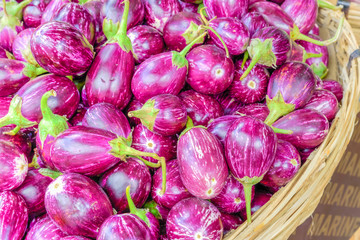 Full rattan basket of purple and oval shape Indian eggplants at street market in Little India, Singapore