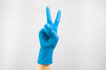 hands in medical gloves show
peace