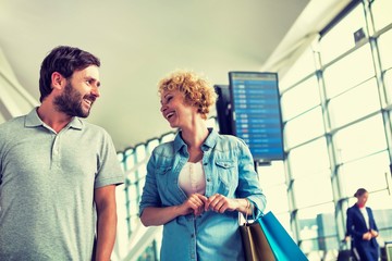 Obraz premium Mature man hugging his wife from behind while looking through the window in airport 