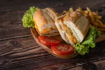 Fast food, sandwich with tomato, lettuce, crispy chicken and cheese as breakfast