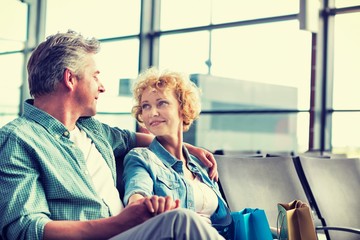 Mature couple sitting while waiting for their flight in airport
