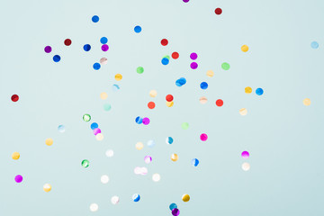 Confetti scattered on the light blue background. Bright dots on the background. - obrazy, fototapety, plakaty
