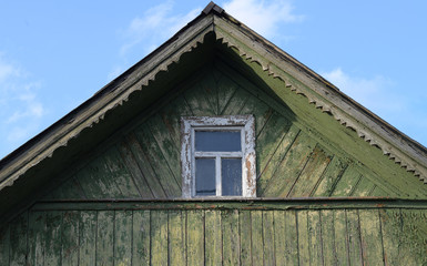 The roof of a small village house with a small white window