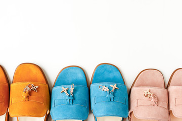 Stylish women's spring or summer shoes, flip flops of different colors on a white background. yellow, pink, pigeons for walking along the beach. Flat lay, top view, place for inscription