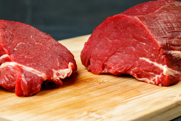 Slice of raw beef fillet on wooden board