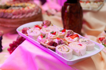 
rolled of fierce and cold salty canapes with white bread stuffed with cold cuts and vegetables and...