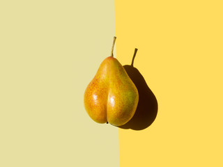 bottom shaped pear on yellow and olive background. top view, space for text