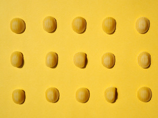 oriecchiette dry pasta pattern on yellow background. horizontal, top view