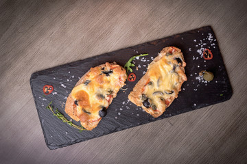 Two brutal sketches with cheese, olives, mushrooms on stone plates. restaurant giving. for the menu of cafe. wooden table