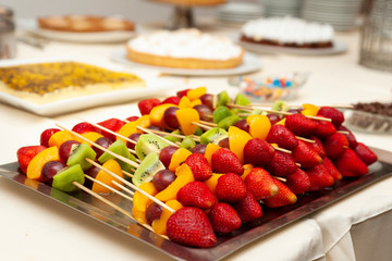 fresh fruits cut and on skewer on event candy table with fondue