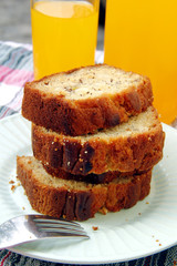 Sliced banana bread loaf and orange juice drink