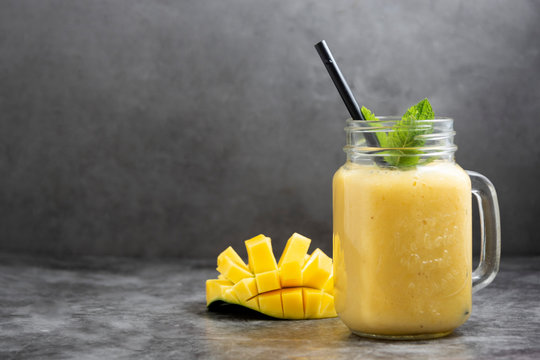 Summer mango and pineapple smoothie. Fresh fruit yellow smoothie. Copy space.