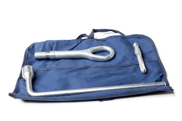Set for towing in the event of a car breakdown - hook, spanner key on a blue bag-cover and a white background in a photo studio. Case for transporting a auto to a service station or workshop. © Aleksandr Kondratov