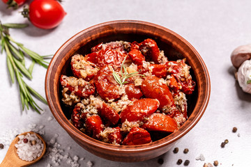 Sun-dried tomatoes with garlic, oregano, olive oil in bowl on a light table, top view