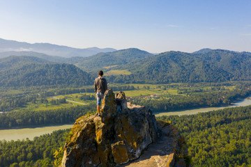 Hiker standing on top of a mountain and enjoying view of Altai