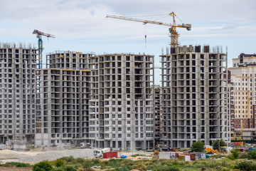Fototapeta na wymiar construction of multi-storey residential buildings. Tower cranes at a construction site.