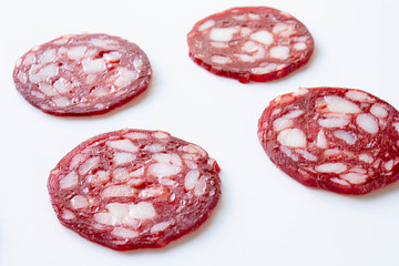 Slices of smoked sausage close up on white background