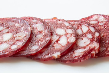 Slices of smoked sausage close up on white background