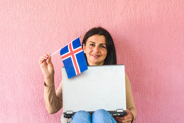 woman with laptop computer and flag of   Iceland