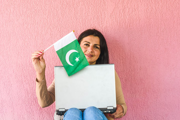 woman with laptop computer and flag of  Pakistan