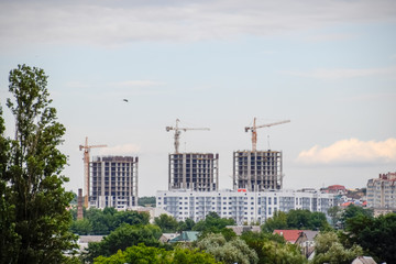 construction of multi-storey residential buildings. Tower cranes at a construction site.