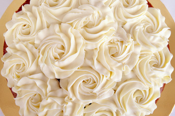 Cake decorated with beautiful icing made of rose flowers for Mother's day celebration or for a special love one. Cake topped with creamy buttery icing shaped in a floral arrangement, closeup top view.