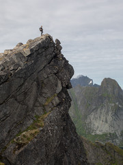 A Norwegian mountaineer stands on the peak of a mountain.