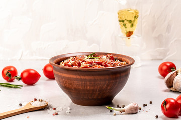 Sun dried tomatoes in olive oil with garlic, oregano in bowl on gray table, place for text