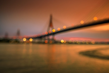 The blurred background of the twilight evening by the river, the natural color changes, the bridge over the river (Bhumibol Bridge) is one of the major transportation bridges in Bangkok, Thailand