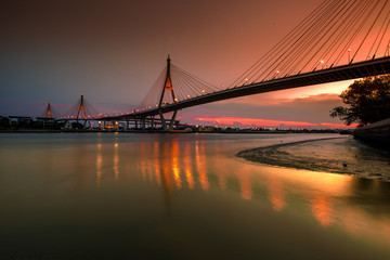 Fototapeta na wymiar The blurred background of the twilight evening by the river, the natural color changes, the bridge over the river (Bhumibol Bridge) is one of the major transportation bridges in Bangkok, Thailand