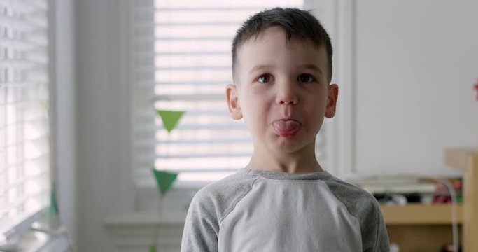 Toddler making silly faces towards camera - medium shot - slow motion