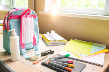 Back to school after quarantine concept. Backpack with school supplies and sanitizer and medical protective mask. Preparation for school, the beginning of the school season.