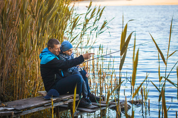 Cute boy with father catches fish on a summer lake. Activity in nature fishing. Happy childhood