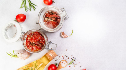 Sun dried tomatoes with fresh herbs and spices. Delicious snack on a light background, top view. Long banner format. space for text