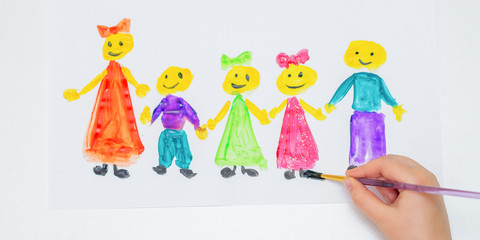 Top view of hand of child drawing children by watercolors on white paper. Children's Day concept.