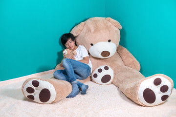 Cute Asian boy together with huge teddy bear