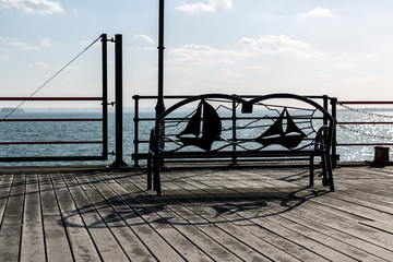 Obraz premium Metal Bench in Front of a Sea or Lake.