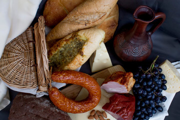 Still-life. Wine. Glass of wine. Cheese. Sausage. Bread. Basket. Grape. A decanter of wine. Nuts...