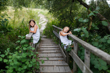 Children siblings play climb on a wooden bridge