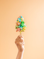 Composition of ice cream made with sweet pop corn being held by one hand