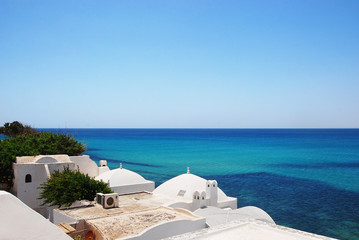 Azure sea, blue sky and white roofs of houses of the medina of Hammamet in Tunisia