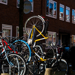 Vertical yellow bicycle in a bicycle rack in Amsterdam